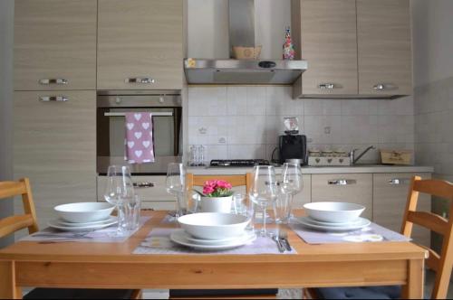 una cucina con tavolo in legno, piatti e bicchieri da vino di Valley House a Roe