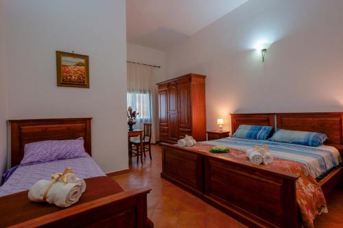 1 dormitorio con 2 camas y toallas. en Bed and Breakfast Cairoli Exclusive Room, en San Pietro Vernotico