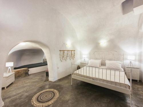 a bedroom with a large bed in a white room at Navita Cave Houses in Fira