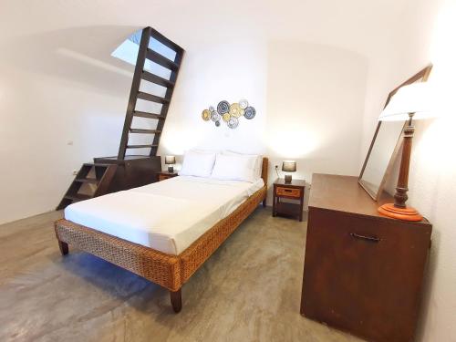 a bedroom with a bed and a ladder at Navita Cave Houses in Fira