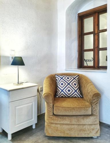 a living room with a couch and a lamp on a table at Navita Cave Houses in Fira