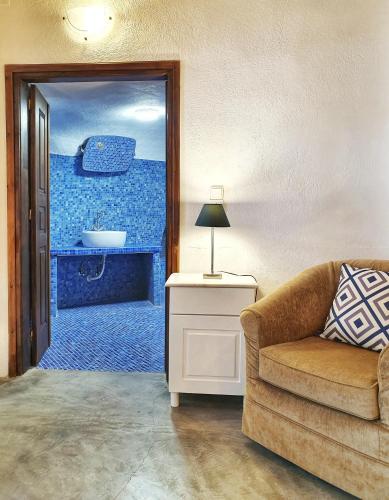 a living room with a couch and a door to a bathroom at Navita Cave Houses in Fira
