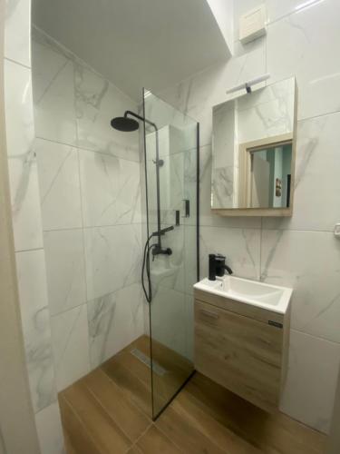 y baño con ducha, lavabo y espejo. en Treasure box apartment _Aristotelous square_, en Tesalónica