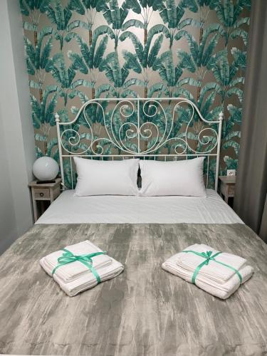 1 cama con 2 toallas y papel pintado en Treasure box apartment _Aristotelous square_, en Tesalónica
