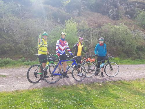 un grupo de personas de pie con bicicletas en un camino de tierra en Applecross B&B & Cabins On NC500, 90 mins from Skye en Applecross