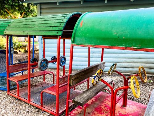 a green and red bench in a playground at Etzel Tami Hospitality in Neot Golan