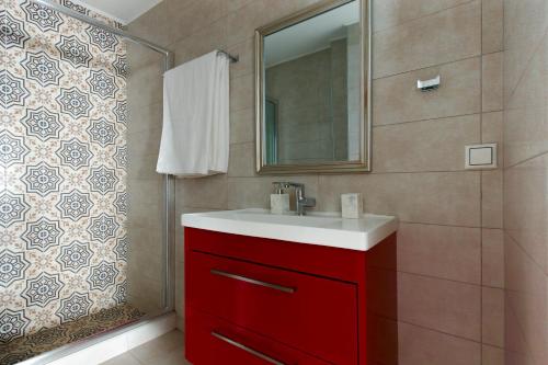 uma casa de banho com um lavatório vermelho e um espelho. em Twin Lofts Ταξιαρχών, a KalamataStay Property em Kalamata