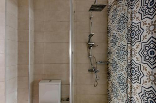uma casa de banho com um chuveiro, um WC e uma cortina de chuveiro. em Twin Lofts Ταξιαρχών, a KalamataStay Property em Kalamata