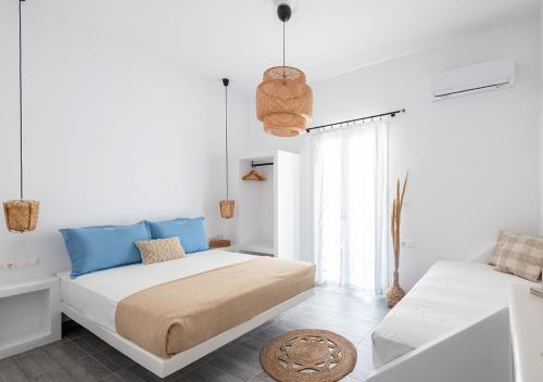 a white bedroom with a bed and a window at Dorkas Luxury Rooms&Apartments in Livadakia