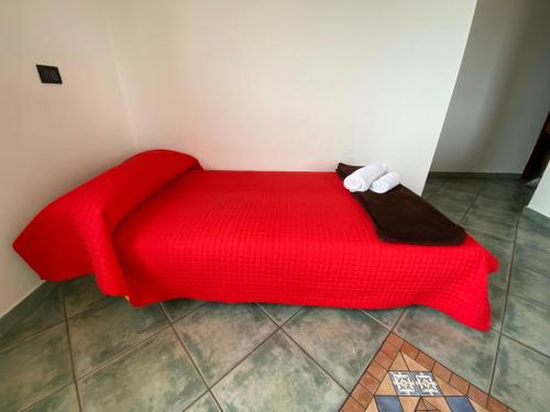 a red bed with a red blanket in a room at Residence Bellavista in Manerba del Garda