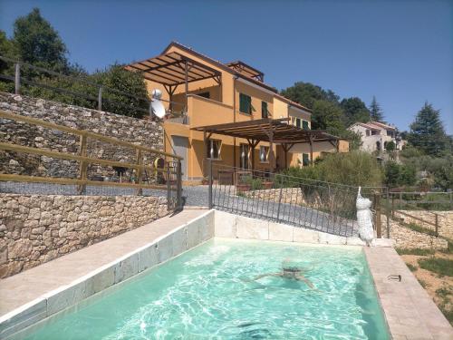 una persona en una piscina frente a una casa en Agriturismo Zenestrin, en Orco Feglino