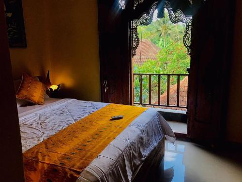 - une chambre avec un lit à côté d'une fenêtre dans l'établissement Ubud home stay, à Gianyar