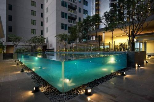 a swimming pool in the middle of a building at night at Summer Suites Apartment @KLCC by Sarah's Lodge in Kuala Lumpur