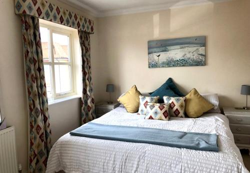 a bedroom with a bed with pillows on it at Norwich City Large Modern Home in Norwich