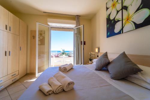 una camera da letto con un grande letto con asciugamani di Melody Hotel a Cervia