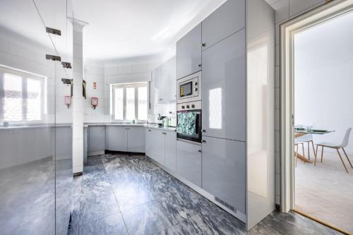 a kitchen with white cabinets and a dining room at Green Urban Oasis in Portimão