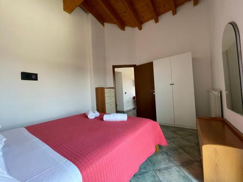 a bedroom with a bed with a red blanket at Residence Bellavista in Manerba del Garda
