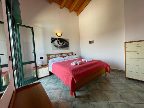 a bedroom with a bed with a red blanket at Residence Bellavista in Manerba del Garda