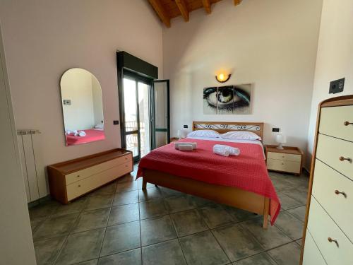 a bedroom with a bed with a red blanket and a mirror at Residence Bellavista in Manerba del Garda