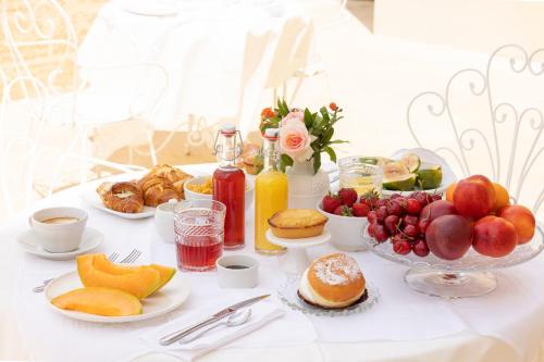 a table with breakfast foods and drinks on it at Il Giardino Grande - Dimora in Salento in Parabita