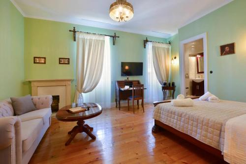 sypialnia z łóżkiem, kanapą i stołem w obiekcie History House w Korfu