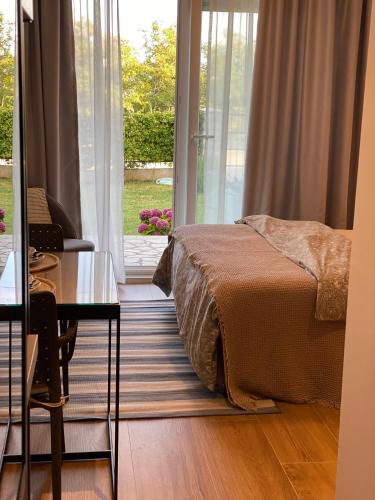 a bedroom with a bed and a desk and a window at VilaA21 in Bar