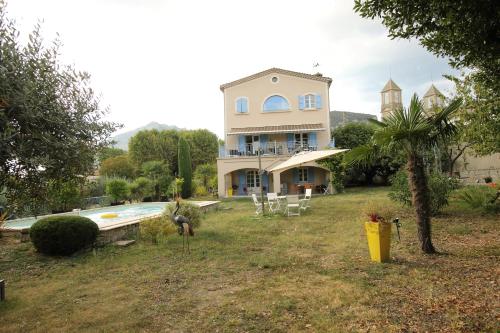 una casa grande con piscina frente a ella en BLANCHARD Alain au 8 Bd du temple, en Saint-Hippolyte-du-Fort