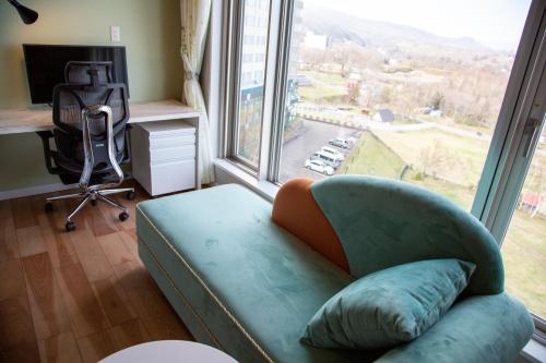 uma sala de estar com um sofá e uma grande janela em Shiretoko Daiichi Hotel em Shari