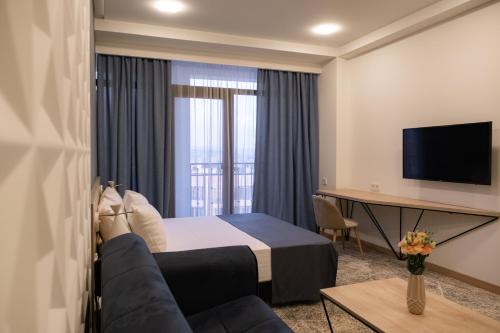 a hotel room with a bed and a tv at Rooftop Apart-Hotel in Yerevan