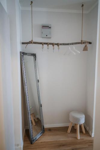 un miroir dans une pièce avec un tabouret et une chaise dans l'établissement Green View Studio, à Bovec