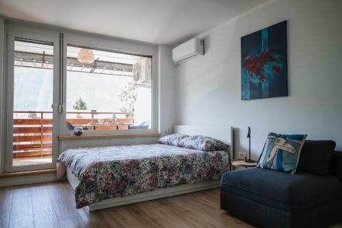 une chambre avec un lit, une chaise et une fenêtre dans l'établissement Green View Studio, à Bovec