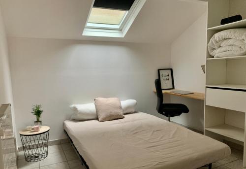 a small room with a bed and a window at Agréable maison avec parking gratuit sur place. in Saint-Denis