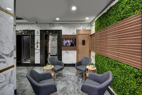 a lobby with chairs and a green wall at Al Nakheel Hotel Apartments Abu Dhabi in Abu Dhabi