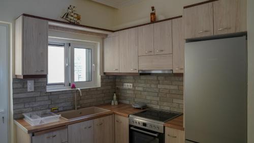 een keuken met houten kasten en een witte koelkast bij KM Beach View apartment in Chania