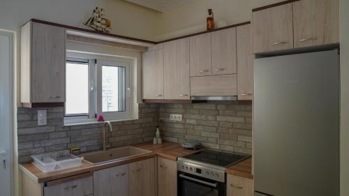 una cucina con mobili in legno e un frigorifero bianco di KM Beach View apartment a Chania