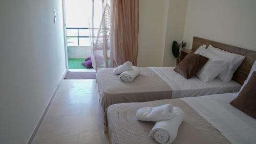 una camera d'albergo con due letti con asciugamani sopra di KM Beach View apartment a Chania