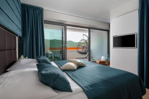 a bedroom with a large bed with a large window at Park Hill Residences in Rabac
