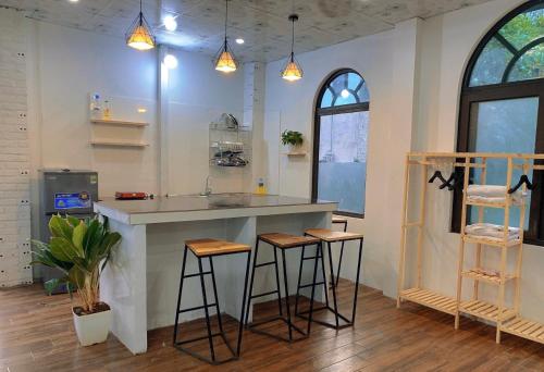 a kitchen with a counter and stools in a room at Catcat Garden House in Sa Pa
