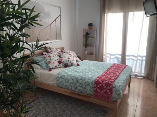 a bedroom with a bed with a blanket and pillows at Apartamento recién reformado con vistas al río in Balaguer