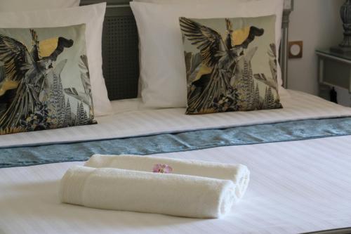a white towel on a bed with two pillows at Loup Castel Boutique Hotel B&B in Le Bar-sur-Loup
