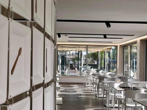a restaurant with white tables and white chairs at Hotel Miramare Chioggia Sottomarina in Sottomarina