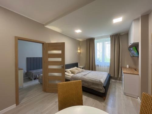 Habitación de hotel con cama, mesa y sillas en Apartamenty Dobranocka, en Krotoszyn