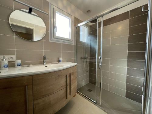 une salle de bain avec une douche, un lavabo et un miroir dans l'établissement Maison à 2 km de la plage avec terrasse, jardin et garage à Brem-sur-Mer - FR-1-224A-27, à Brem-sur-Mer