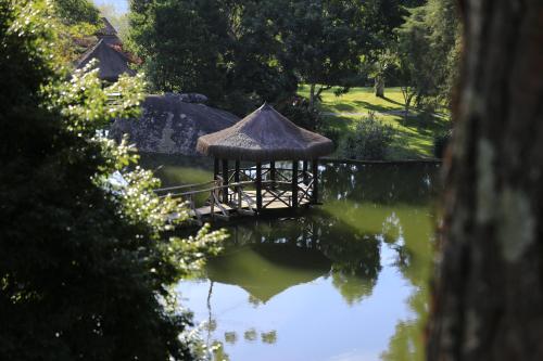 a small gazebo in the middle of a pond at Auberge Suisse Pousada in Nova Friburgo