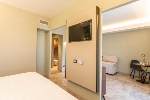 a bedroom with a bed and a flat screen tv at Solmaris Tropea Rooms & Suites in Tropea