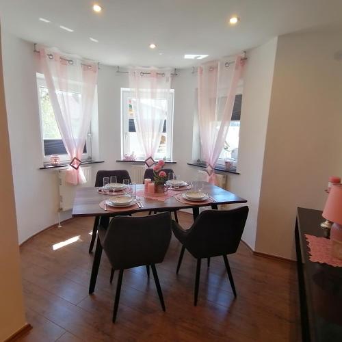 a dining room with a table and chairs and windows at Ferienwohnung Berg(Aus)zeit Ennstal in Öblarn