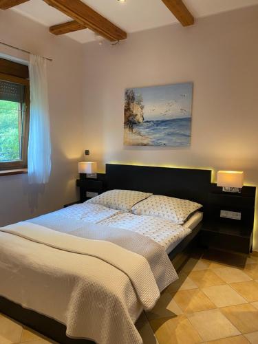 sypialnia z łóżkiem i obrazem na ścianie w obiekcie Villa Leśna w Koszalinie