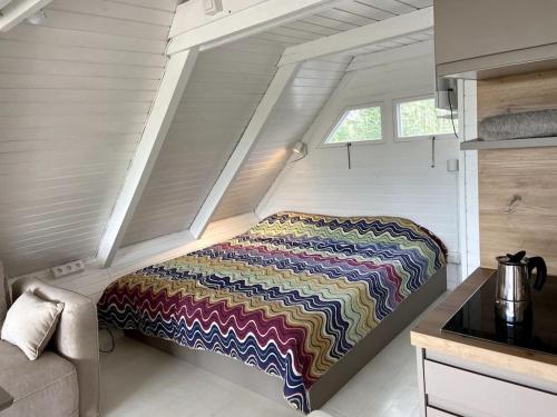 una cama en la esquina de una casa pequeña en Pfahlbau Seehütte am Neusiedlersee - Waterfront 2 en Rust