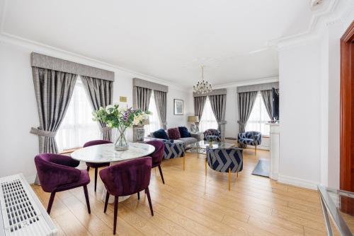 salon ze stołem i fioletowymi krzesłami w obiekcie CARLTON COURT - MAYFAIR w Londynie