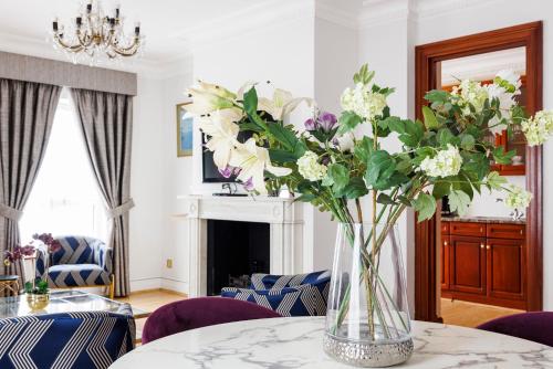 a vase of flowers on a table in a room at CARLTON COURT - MAYFAIR in London
